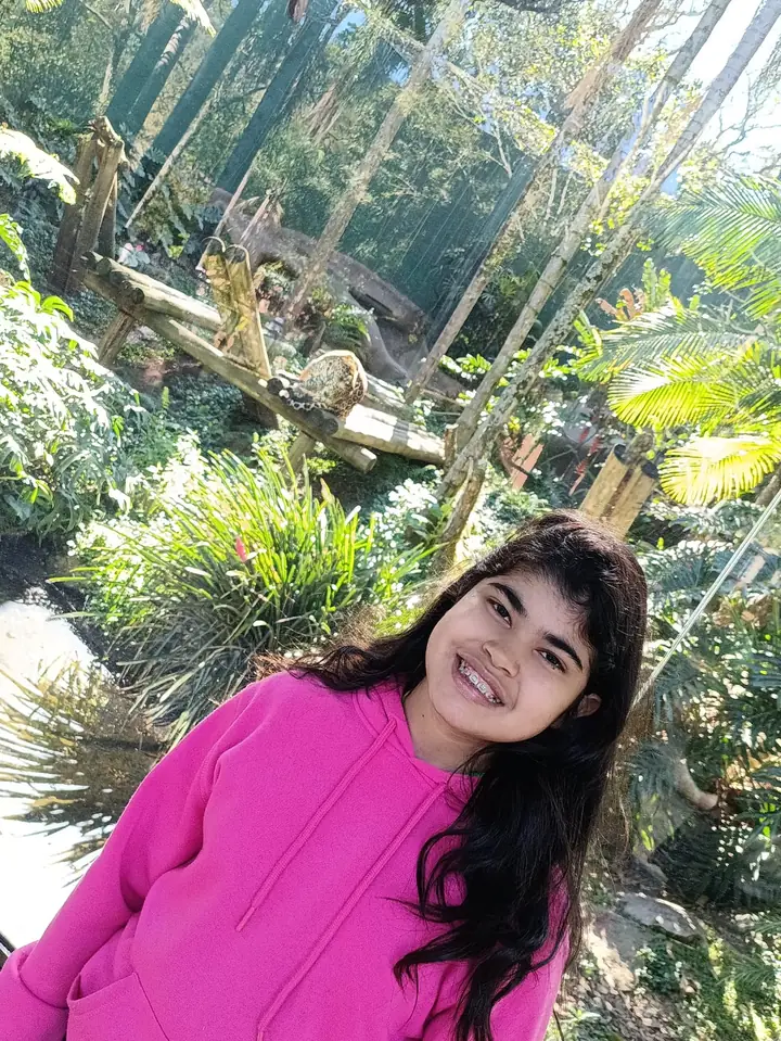 Clara de moletom rosa num jardim
