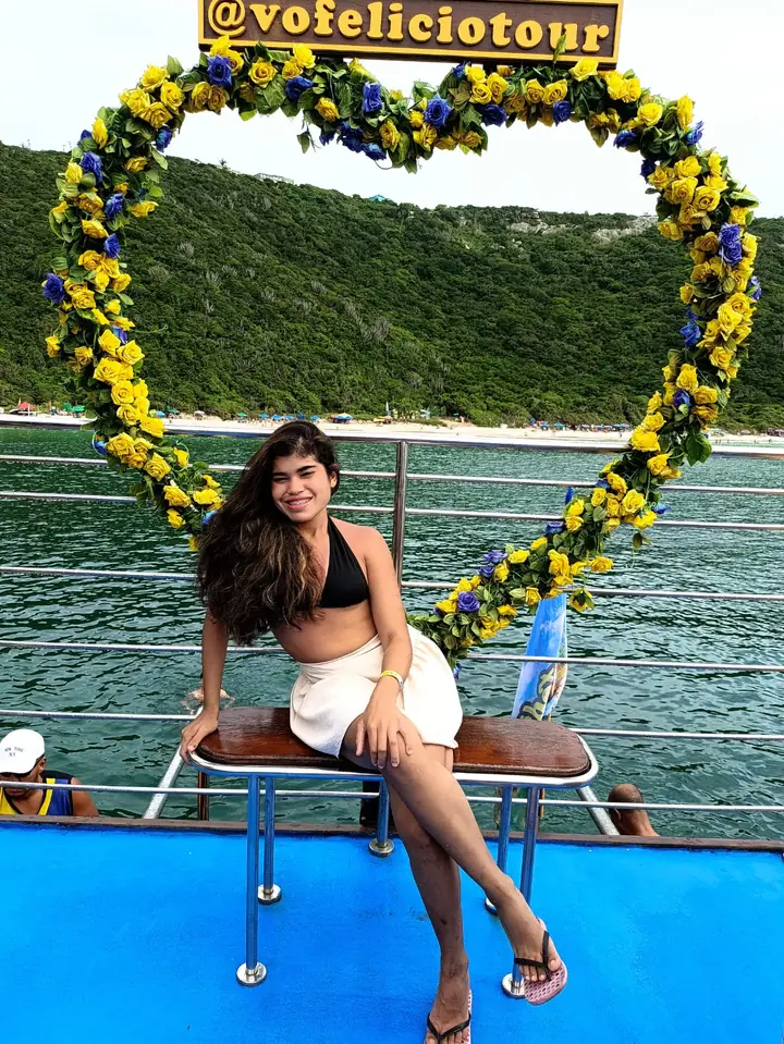 Clara num barco, sob um arco de flores